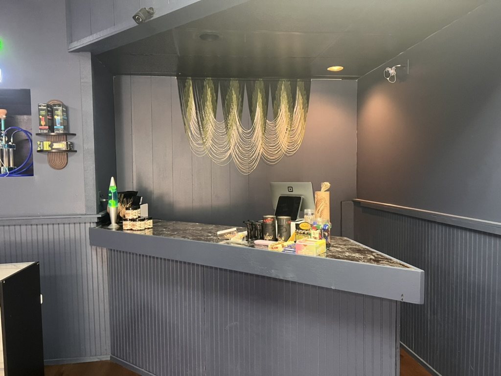 Chilla Smoke checkout counter with dark walls and chain decor